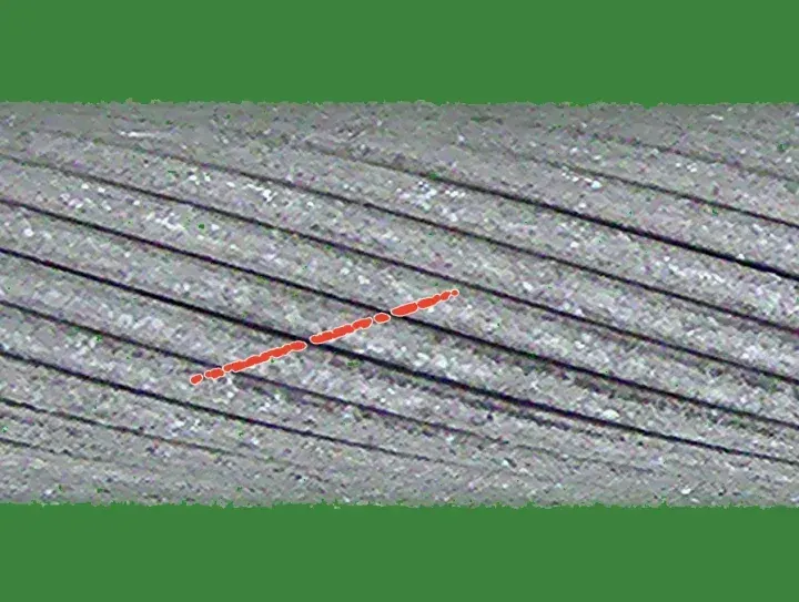 Training crop with a drawn crown scratch: a dashed bright line across the strand crowns along the lay, outlined in red.