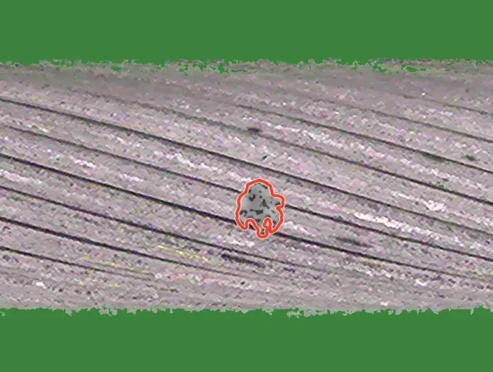 Training crop with a drawn weld blob: a dark irregular spot on the strands, outlined in red.